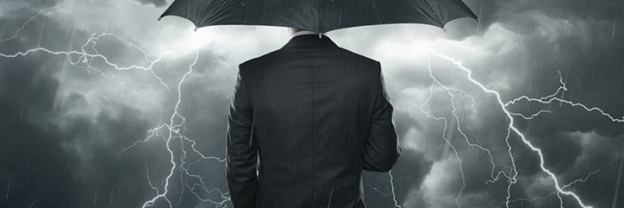 Business man under umbrella in storm